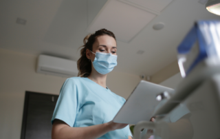 Infirmière Diplômée d'État, en blouse bleu, qui tient un porte document