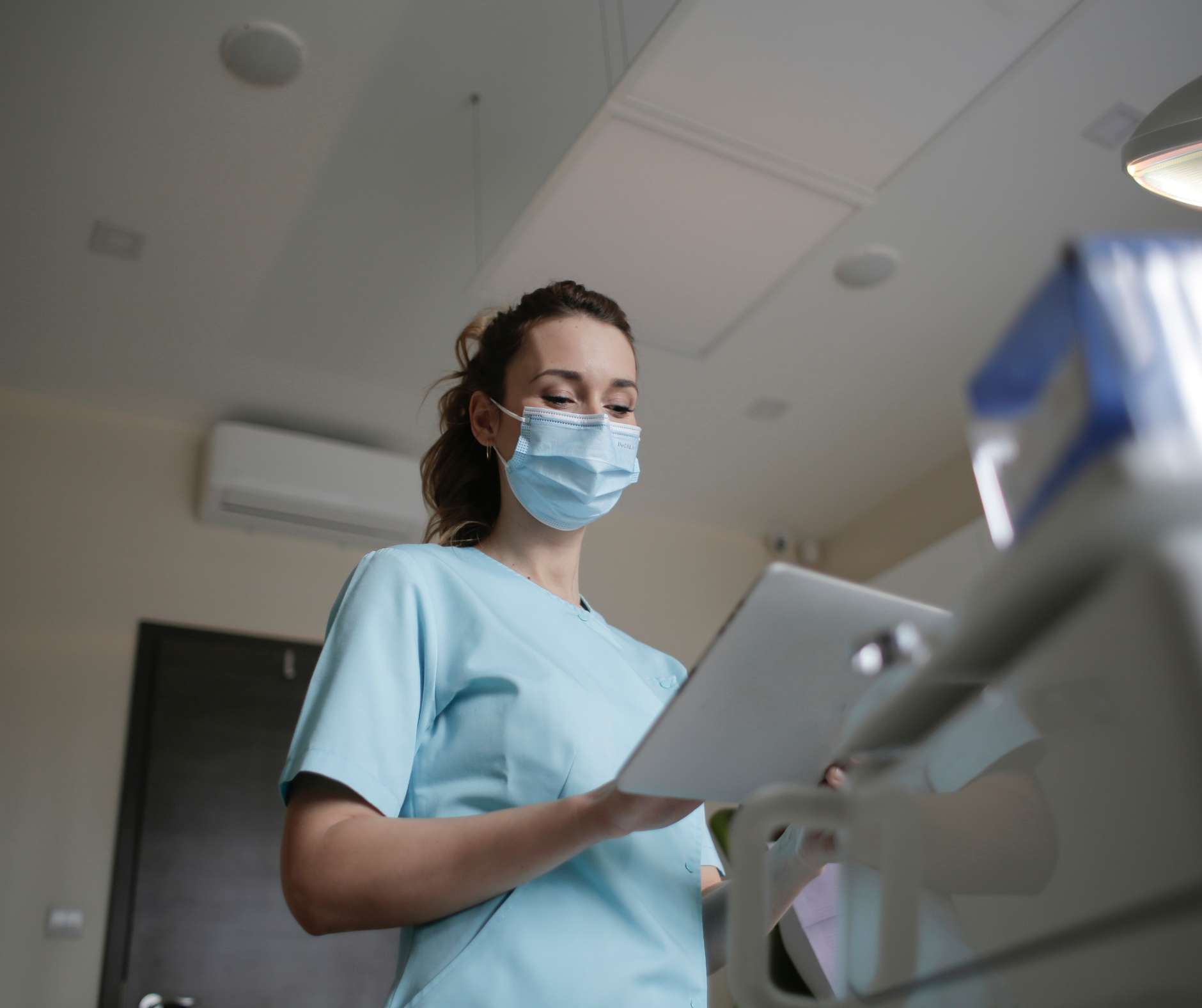 Infirmière Diplômée d'État, en blouse bleu, qui tient un porte document